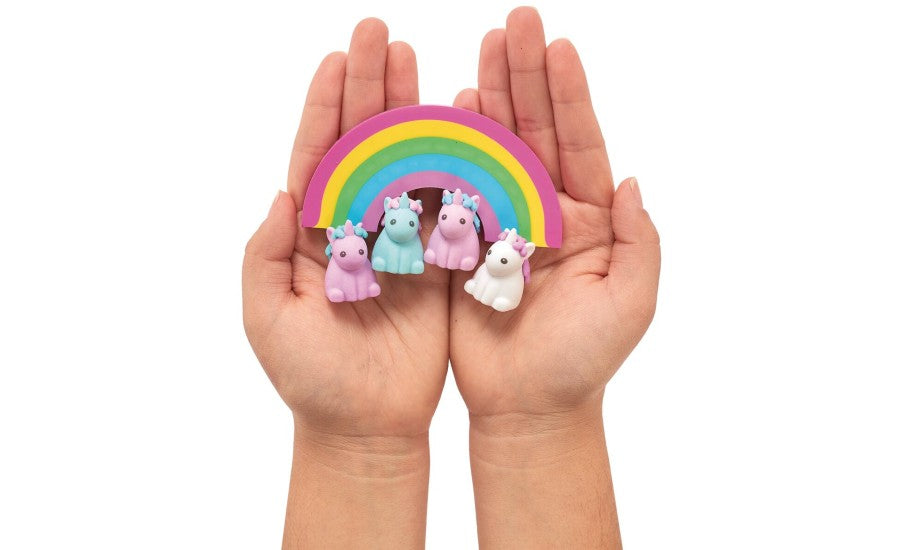 Hands holding rainbow and unicorn erasers