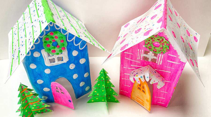 blue and pink paper houses with green trees on white background