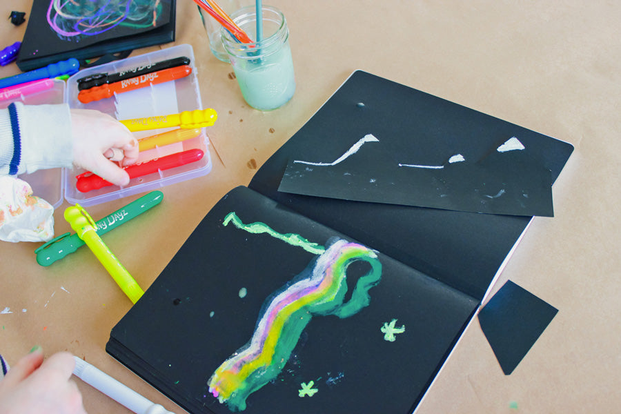Kane focusing on a single shape of bright colors for his version of the Northern Lights on the black paper in The Paper Works Sketchbook.