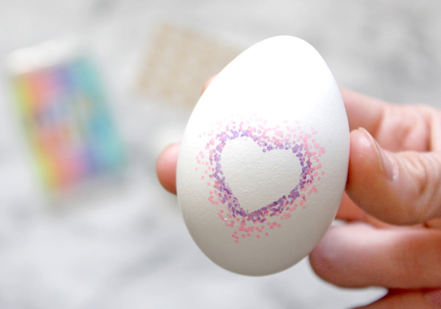 Easter egg decorating with pink and purple pointilism