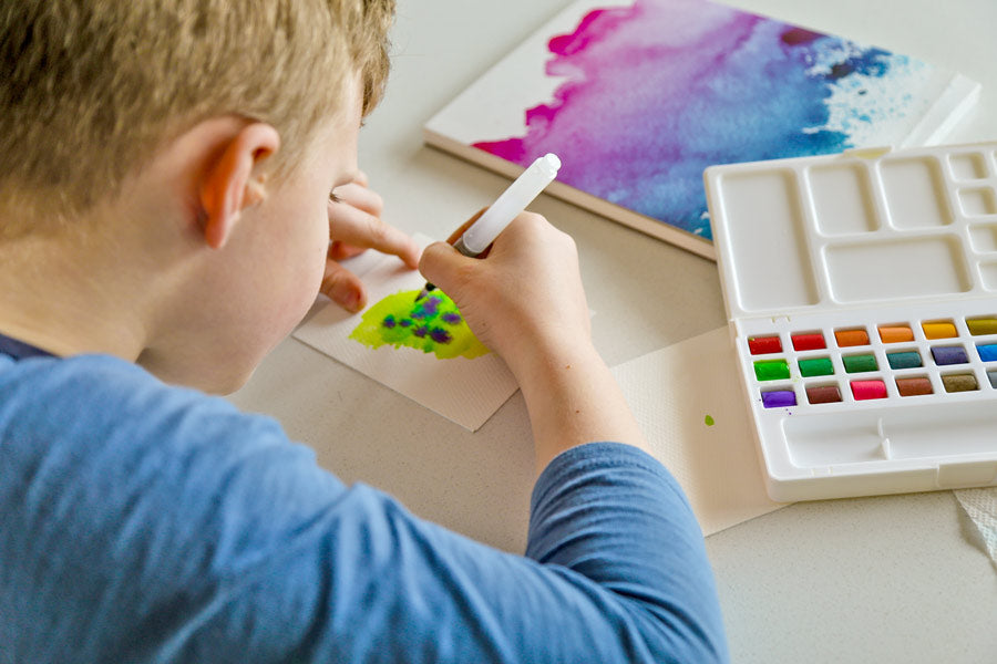 Boy using water brush from Chroma Blends watercolor travel set