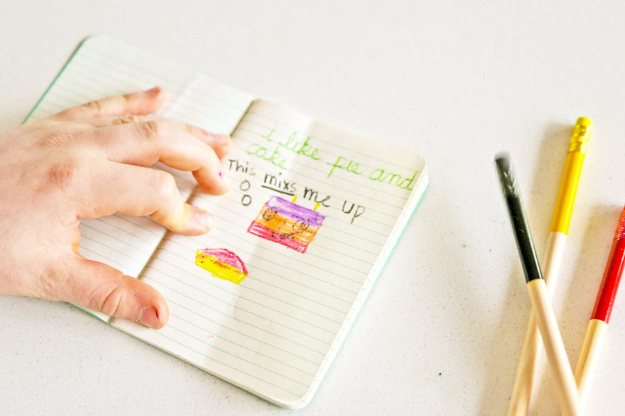 Writing and drawing with colored pencils in a pocket notebook