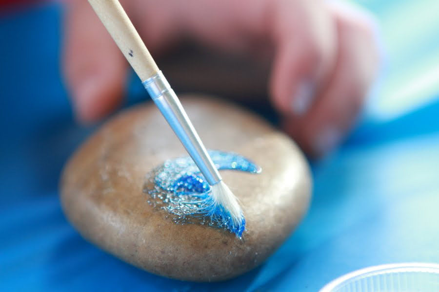 Painting rock with blue glitter paint