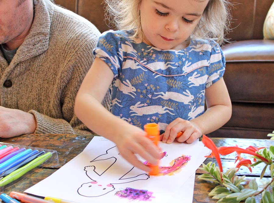 Girl coloring with orange Chunkies Paint Sticks