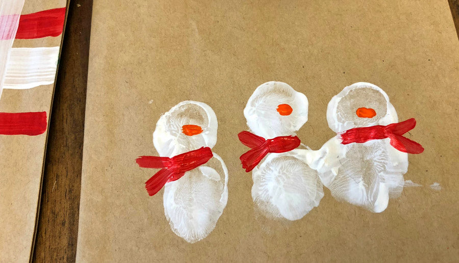 finger painting snowman on the DIY holiday gift bags
