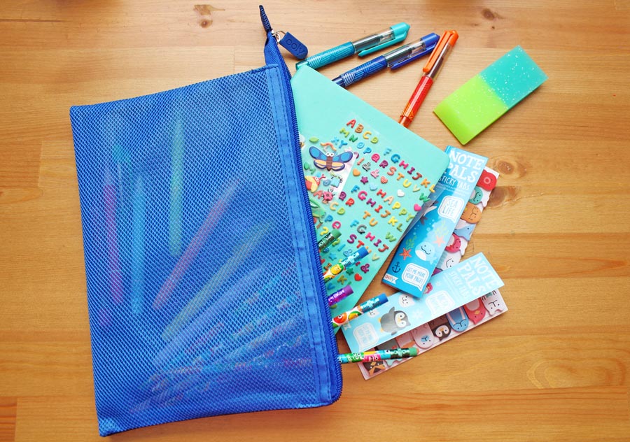 OOLY stickers and other writing supplies inside a blue zipper pouch