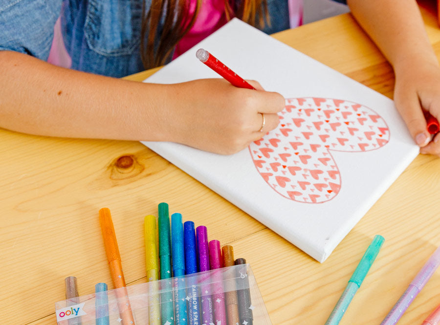 coloring hearts with rainbow sparkle glitter markers on white a canvas
