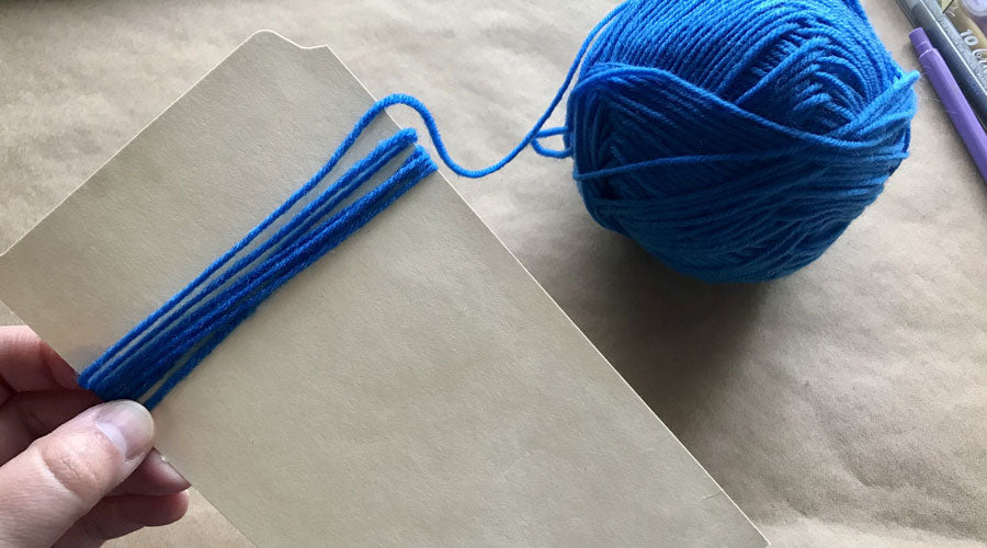 ball of yarn with end wrapping around paper
