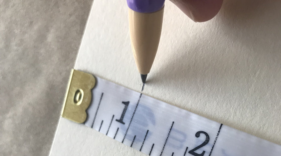 measuring tape with hand drawing a line at 1 inch