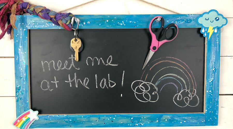 blue glitter framed chalkboard with patches on the corner, scissors and keys
