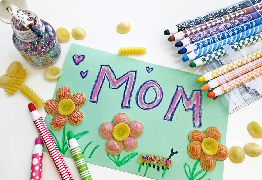 "mom" written on green paper with noodle flowers and crayons