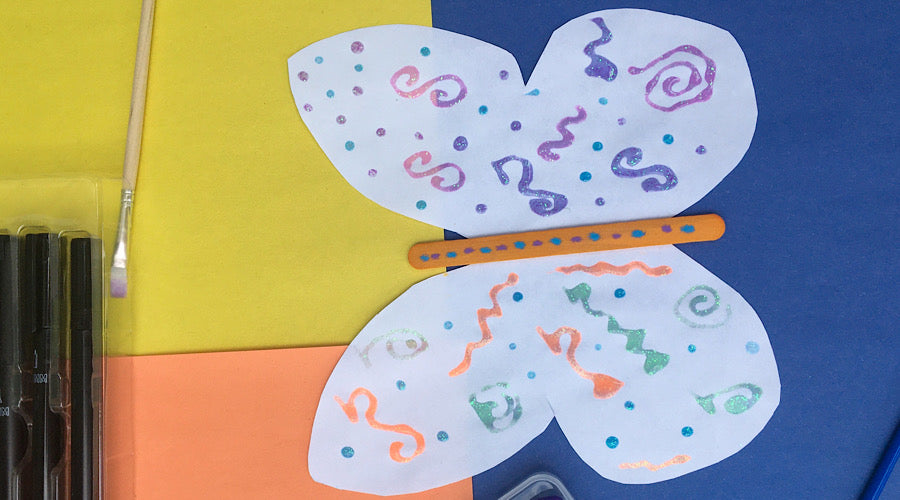white paper butterfly decorated with sparkle glitter glue