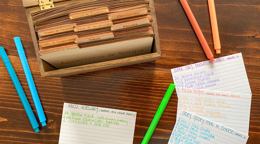 wooden recipe box, colorful markers and index cards on wooden surface