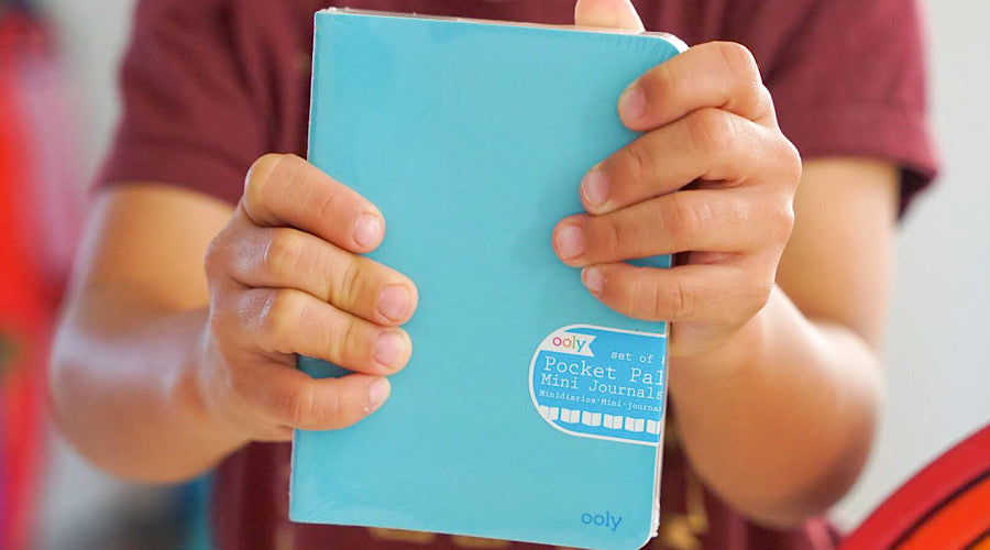 child holding blue notebook