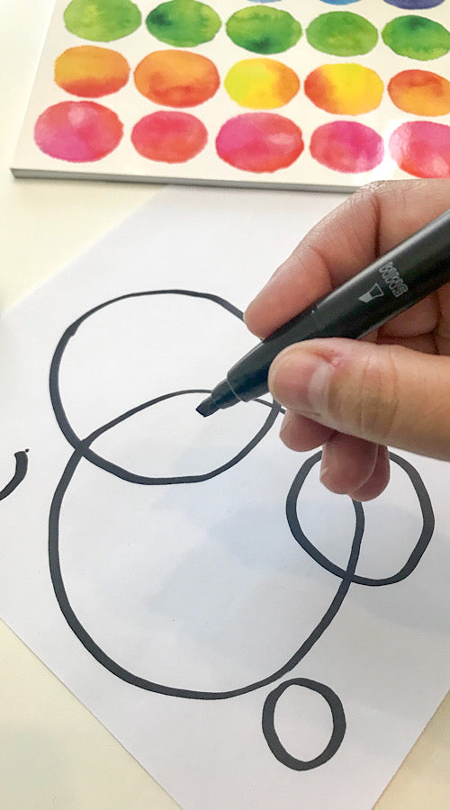hand drawing black circles on white paper