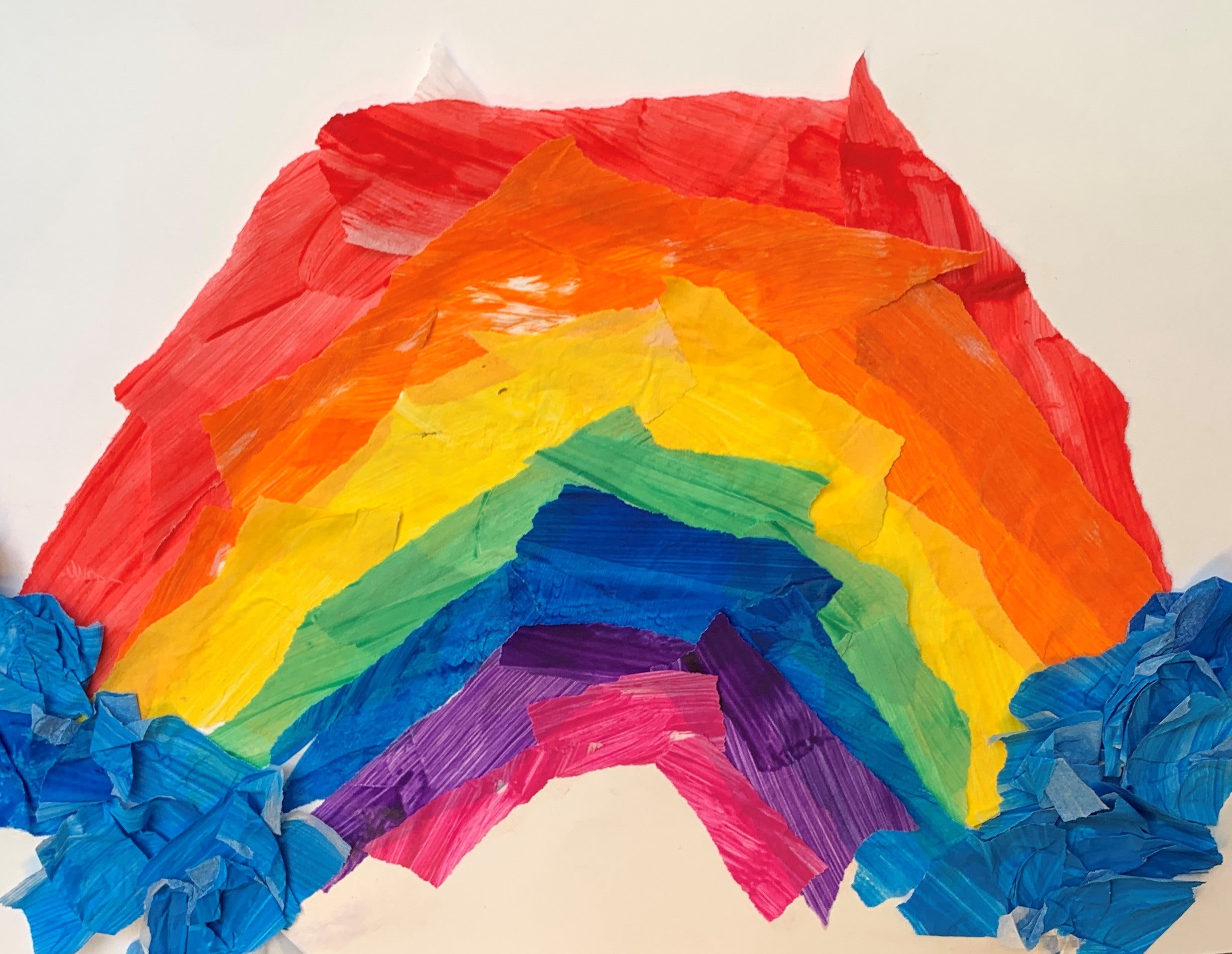 Painted tissue paper in a rainbow shape on white paper