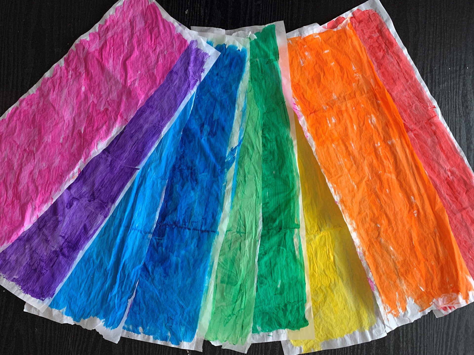 Painted tissue paper in rainbow colors arranged like a fan
