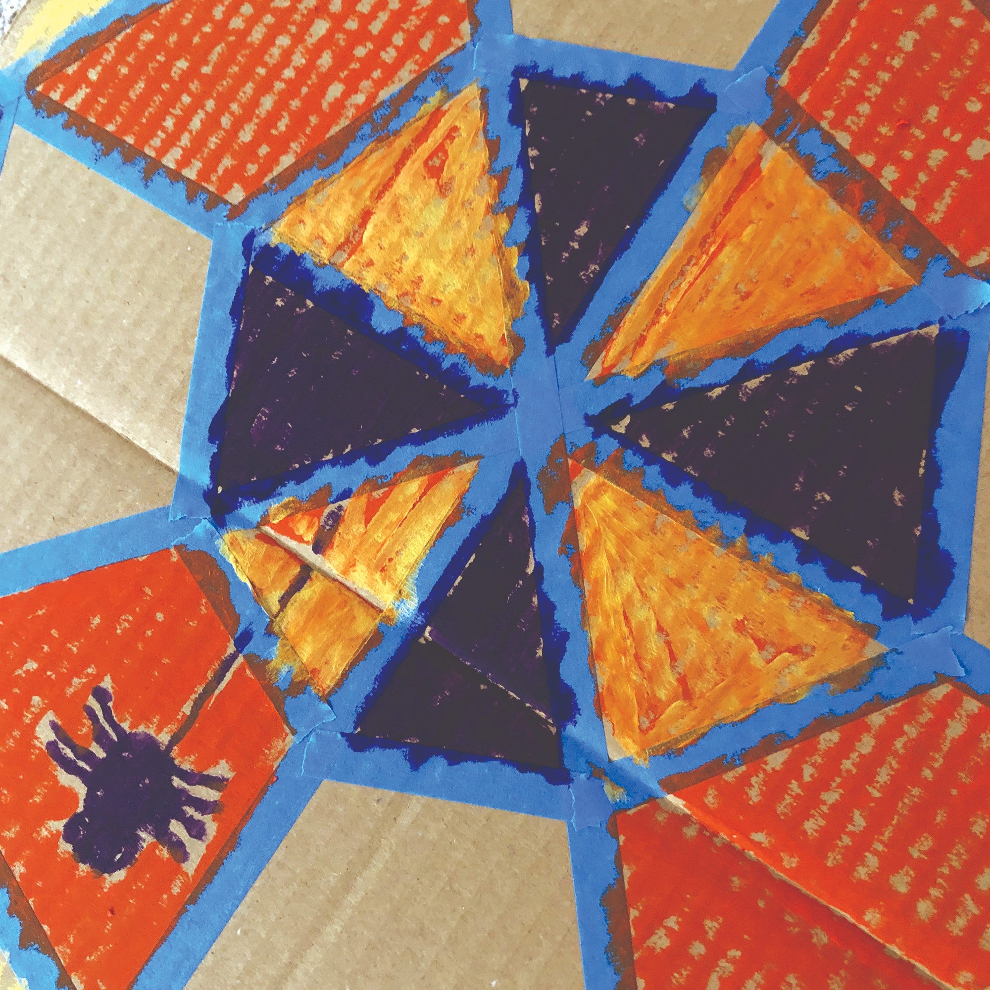 Cardboard spider web with spider and metallic colors on top of regular colors