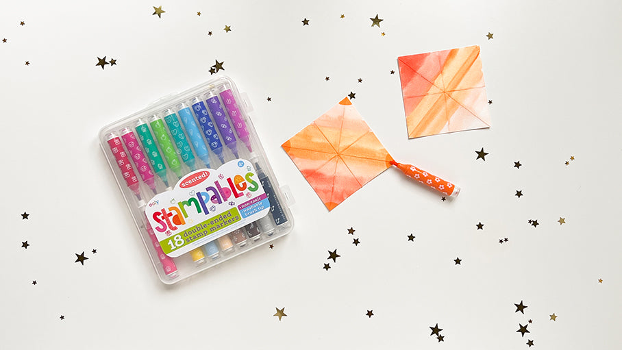 Stampable markers on white table with colorful squares and stars
