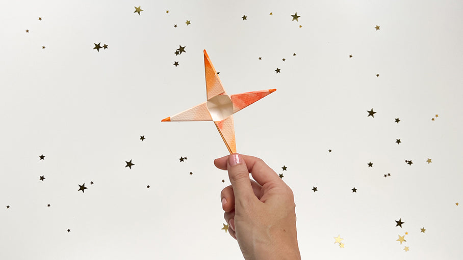 Hand holding folded up and glued paper star