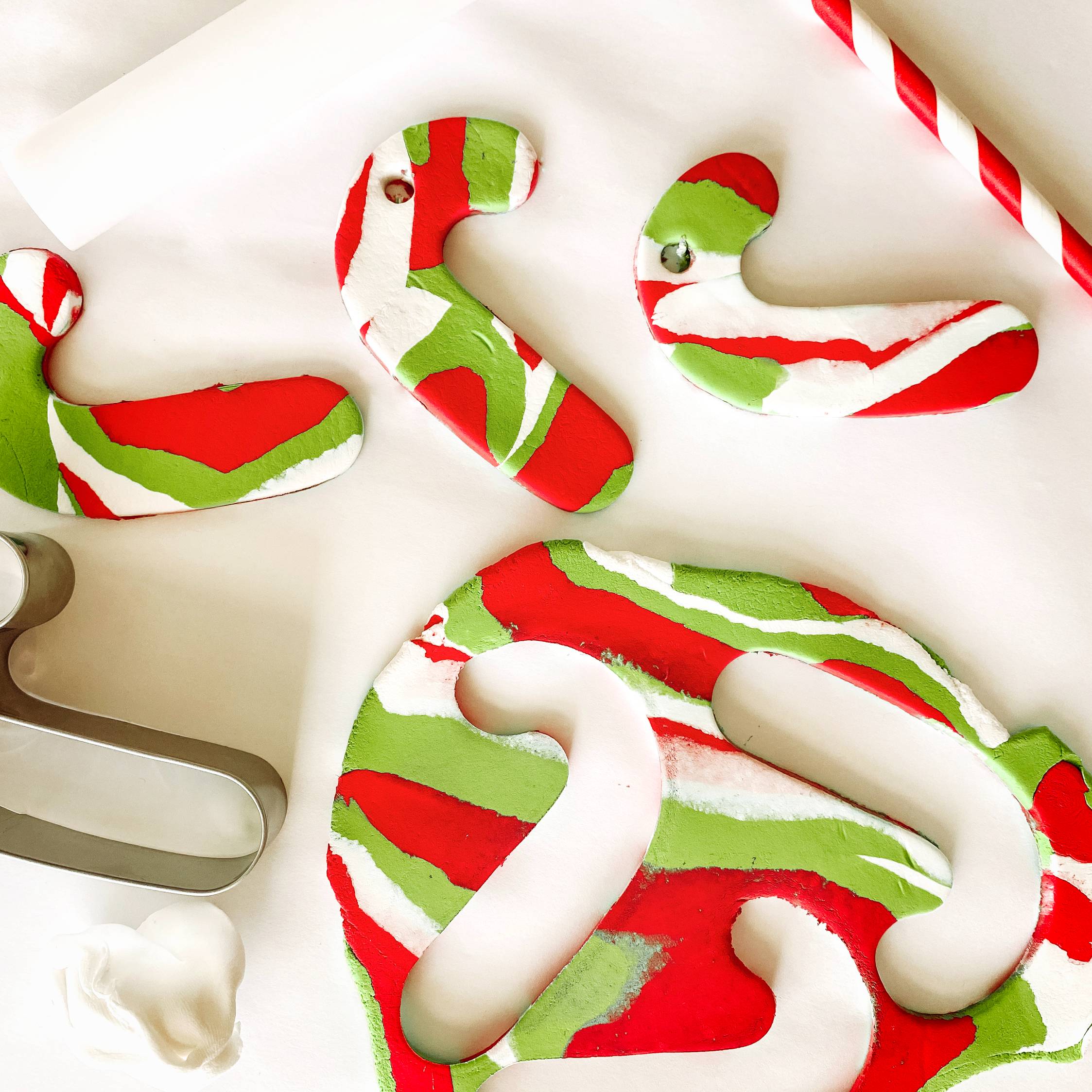 Colorful candy canes made out of clay on a white surface
