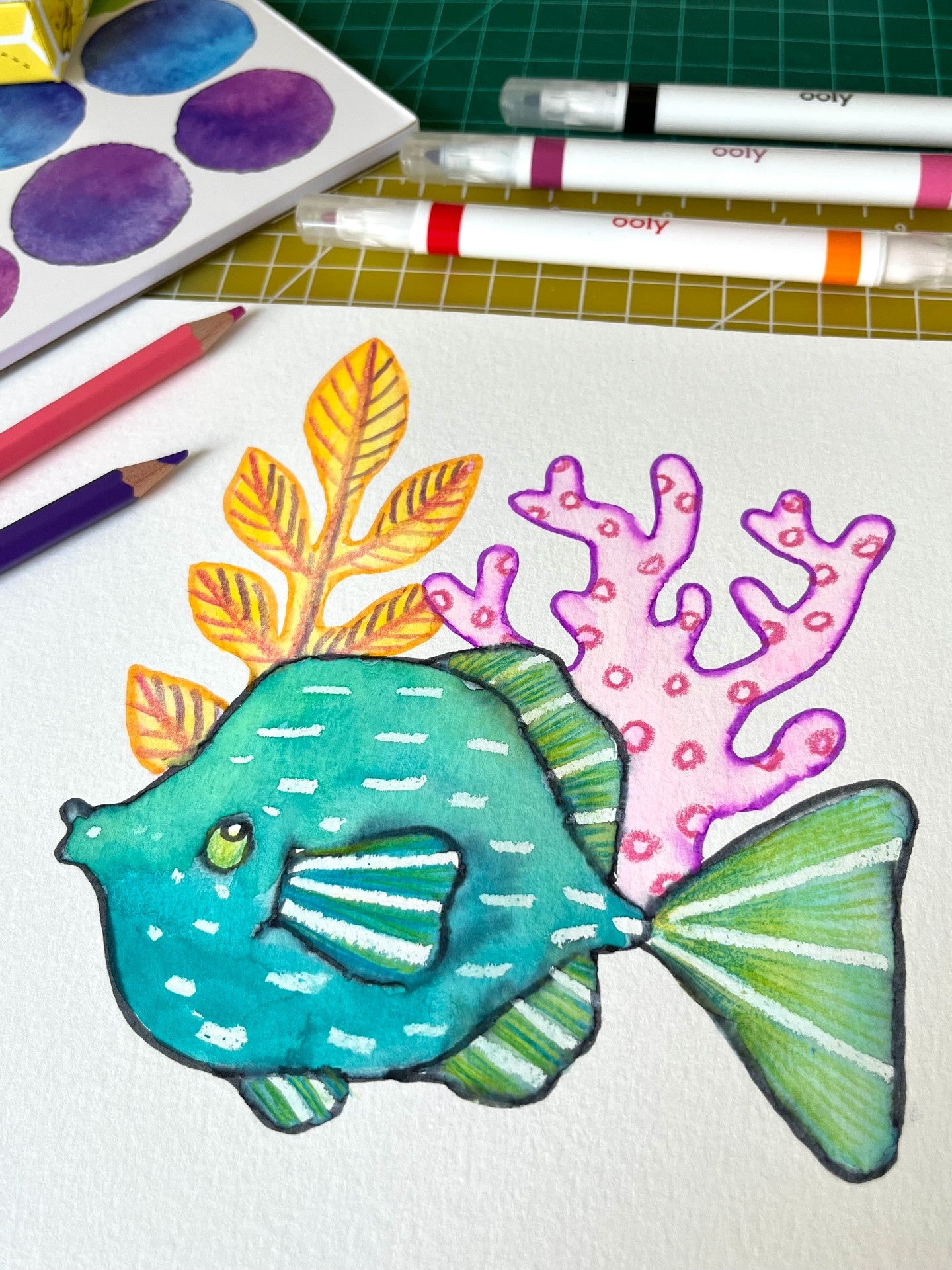 Colored in fish with coral on paper on graph table
