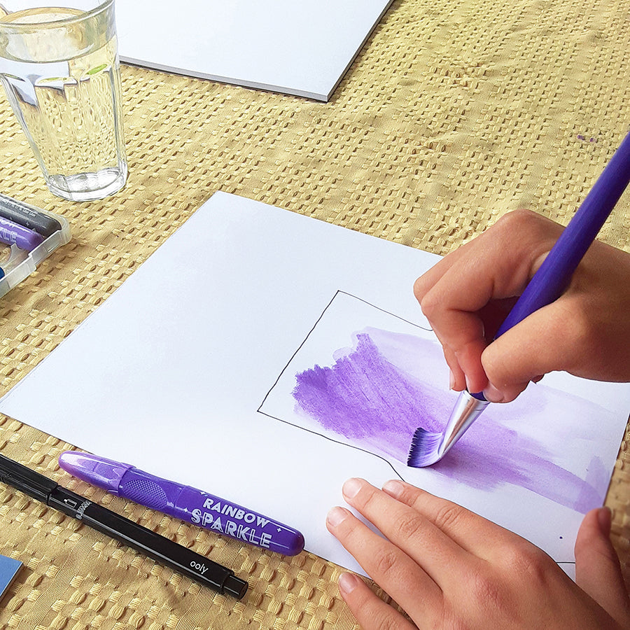 Child using paintbrush to color in purple vase on white sketchpaper