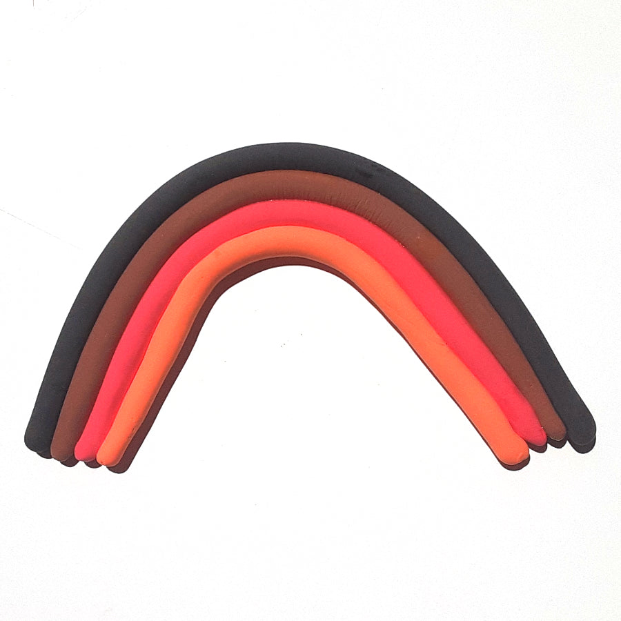 Orange, red, brown and black rolls of dry clay in the shape of a rainbow