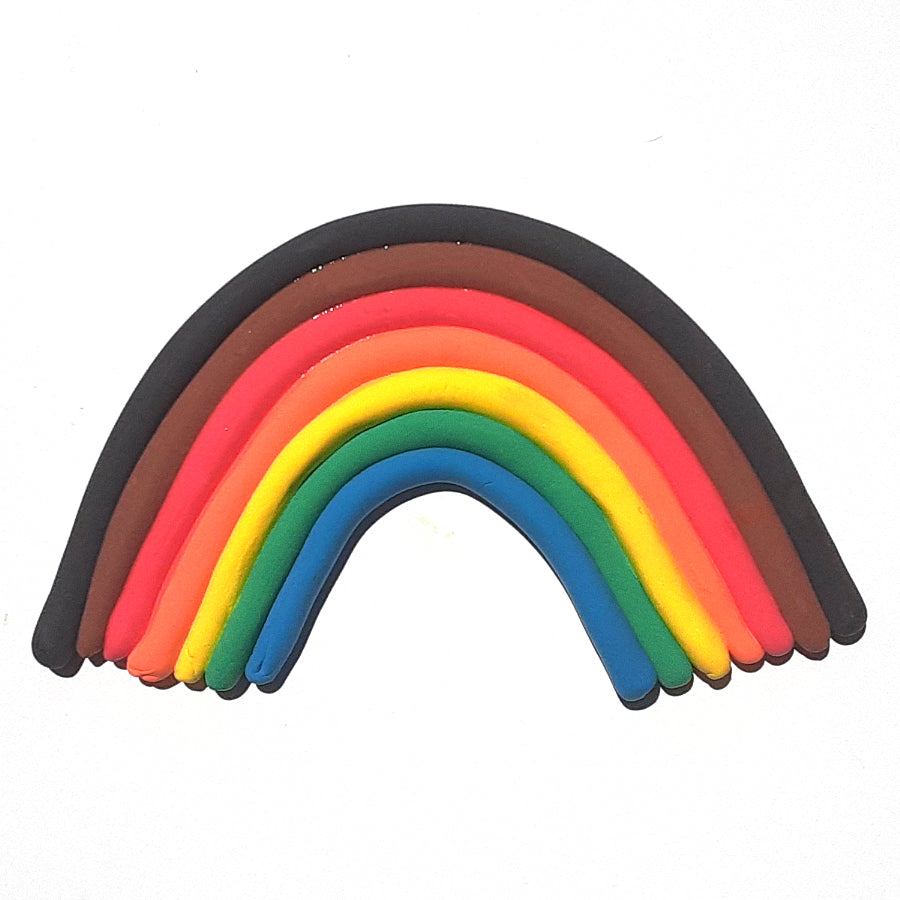 Blue, green, yellow, orange, red, brown, and black dry clay rolled out in long worm like shapes and put together to make a rainbow